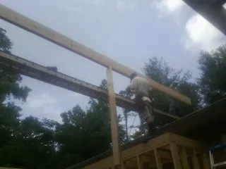 Carpenter setting a ridge beam over a new addition frame — Ice Dam Removal by Roofing Brothers in Golf