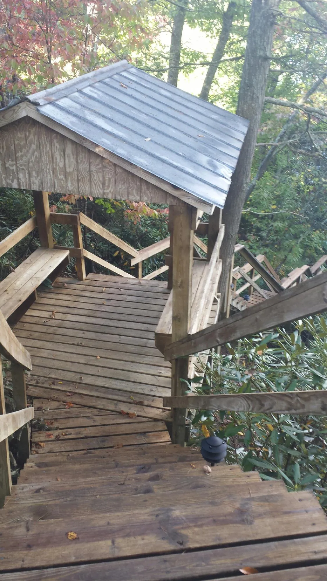 Metal roofed shelter over wooden steps on a wooded walkway — Skylight Repair & Installation work by our crew in Golf