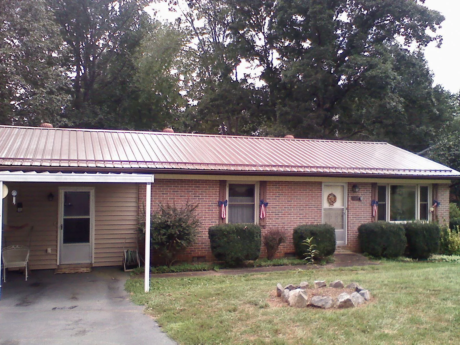 Bronze metal roof and carport on a brick ranch home — Roof Repair work by our crew in Golf
